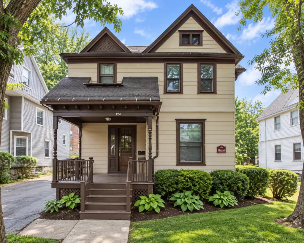 Cream multi-family house with brown trim and a covered front porch at 124 Harvard St. in Rochester, NY
