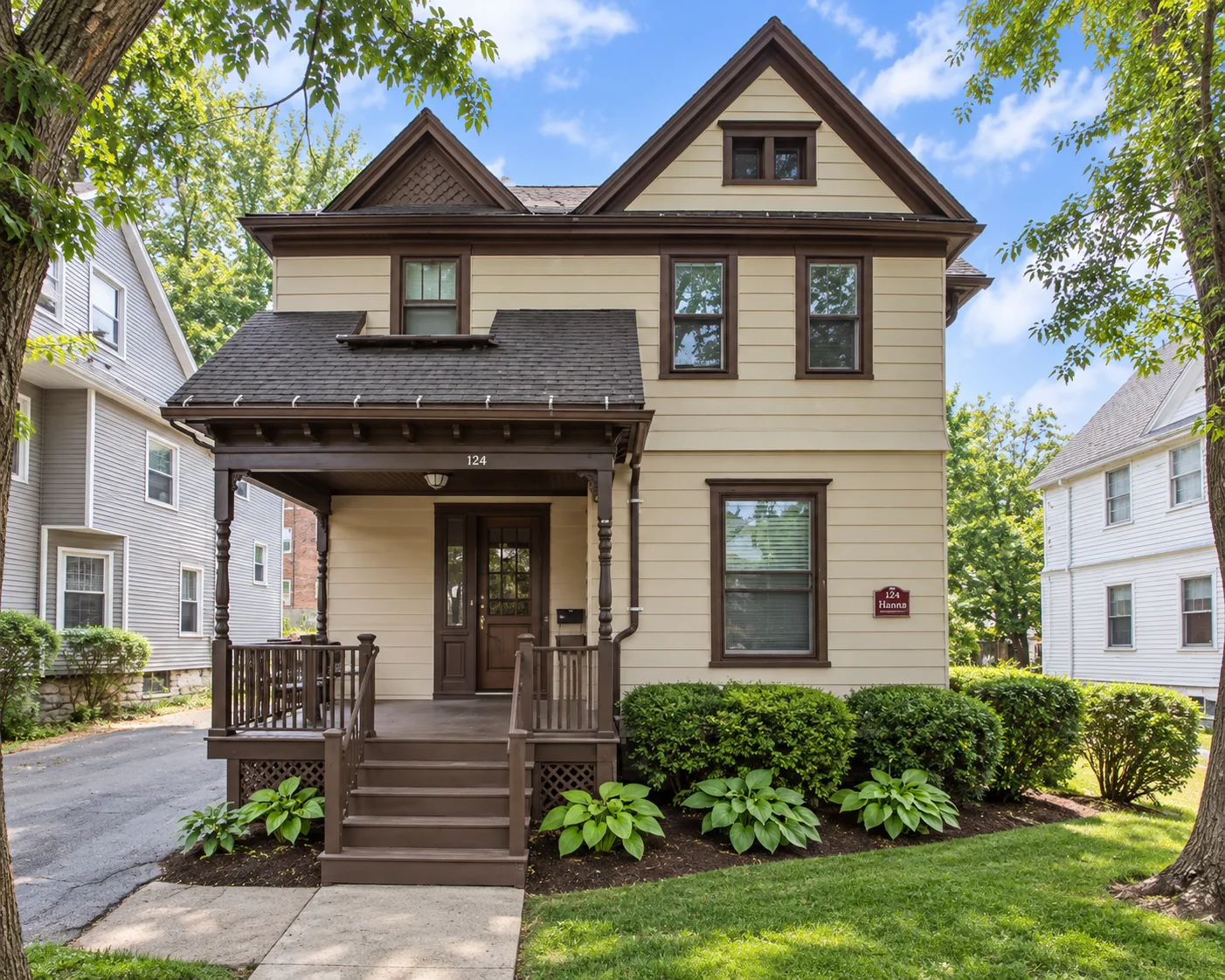 Cream multi-family house with brown trim and a covered front porch at 124 Harvard St. in Rochester, NY