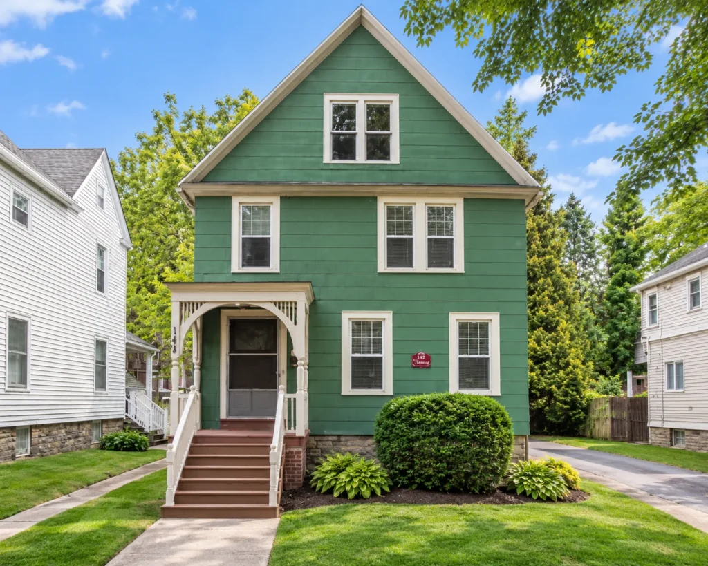 Green multi-family house with white trim and a front stoop at 142 Harvard St. in Rochester, NY