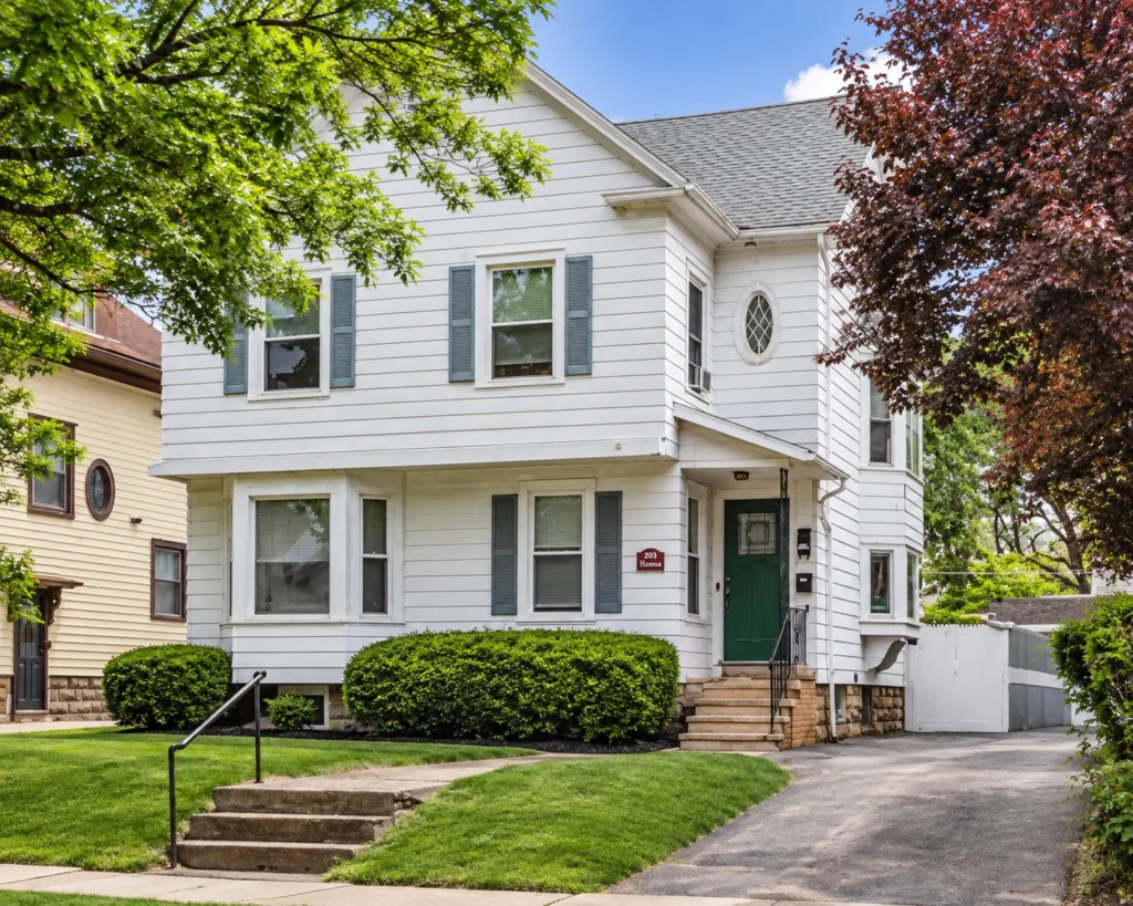 White multi-family house with a green front door at 203 S. Goodman St. in Rochester, NY