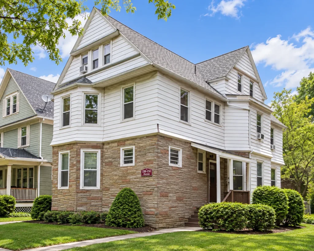 White multi-family house with a stone first floor at 230-232 S. Goodman St. in Rochester, NY
