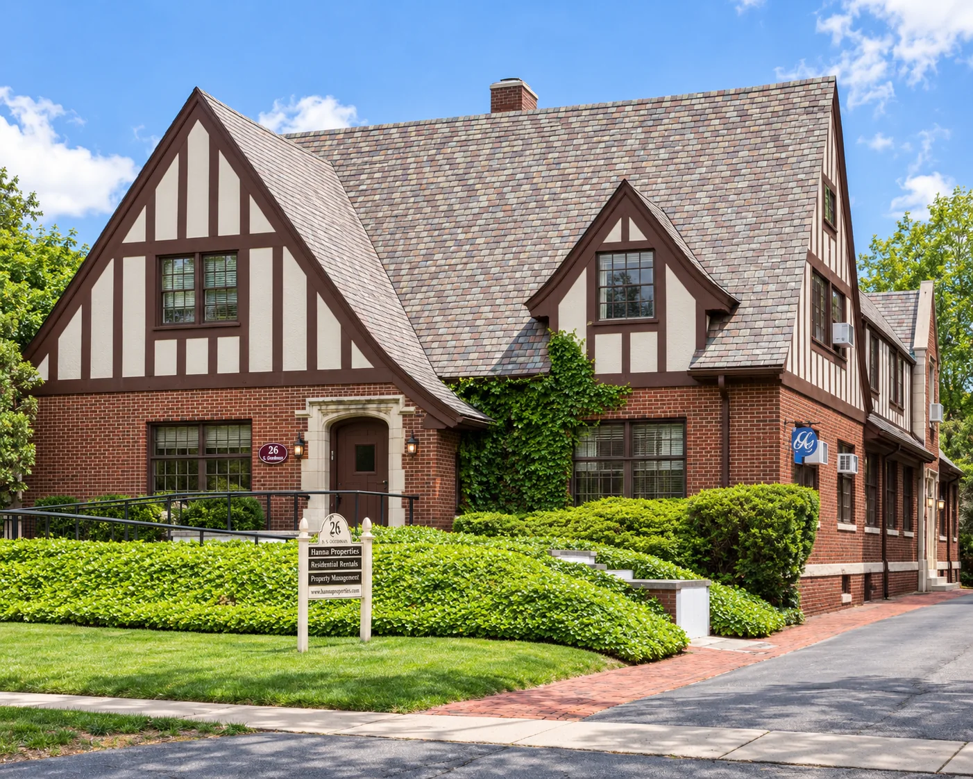 Tudor-style brick building with the Hanna Properties sign at 26 S. Goodman St. in Rochester, NY