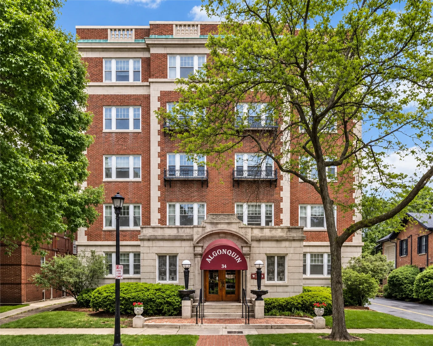 The Algonquin, a historic red-brick apartment building with a maroon entry awning at 34 S. Goodman St. in Rochester, NY